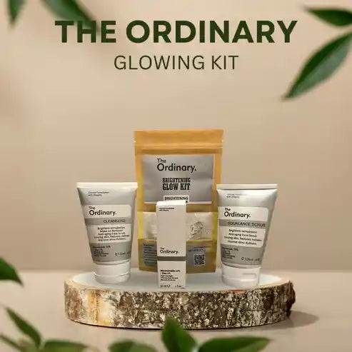 The Ordinary glowing kit with skincare products on a wooden platform against a beige background.