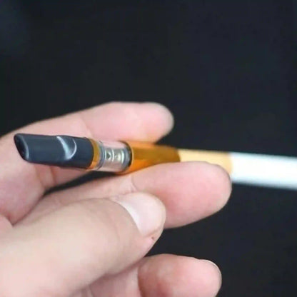 Hand holding a vape pen against a dark background