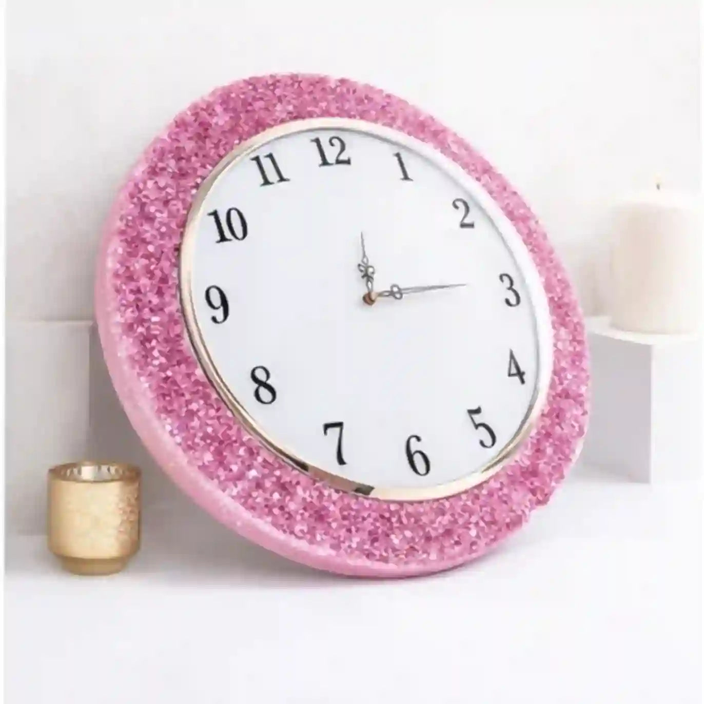 Pink glittery wall clock on a white background