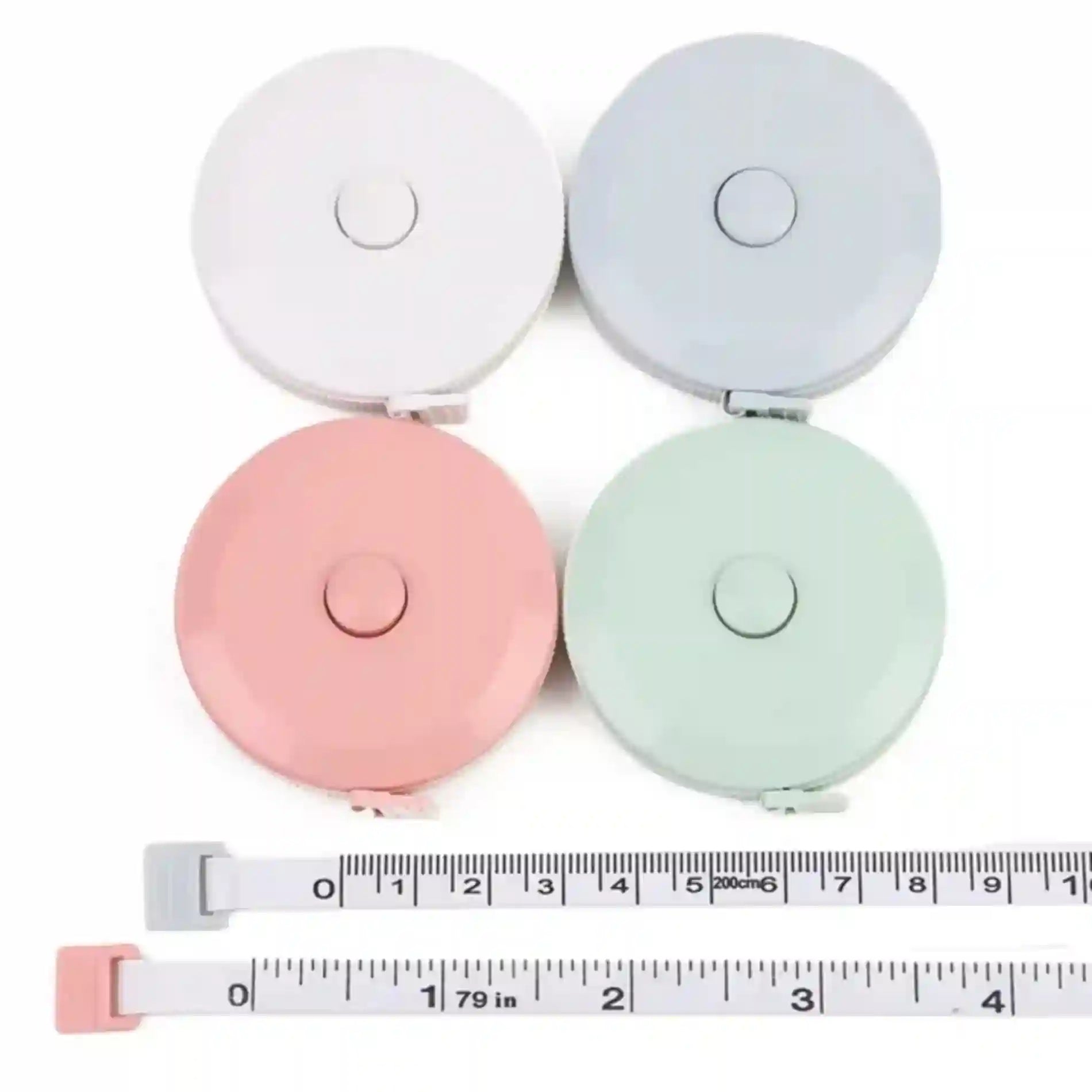 Four retractable measuring tapes in different colors with a ruler at the bottom.