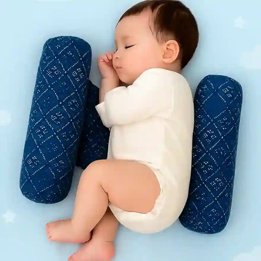 Baby lying on a white cushion with blue pillows on a light blue background