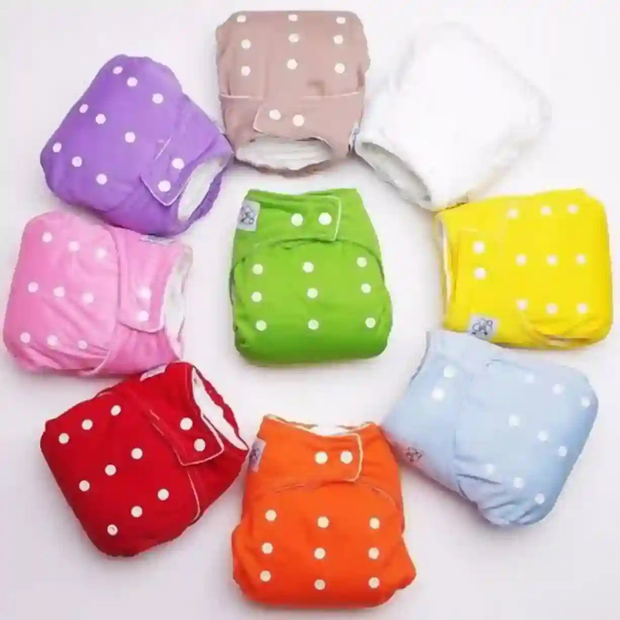 Colorful baby diapers with white polka dots on a white background