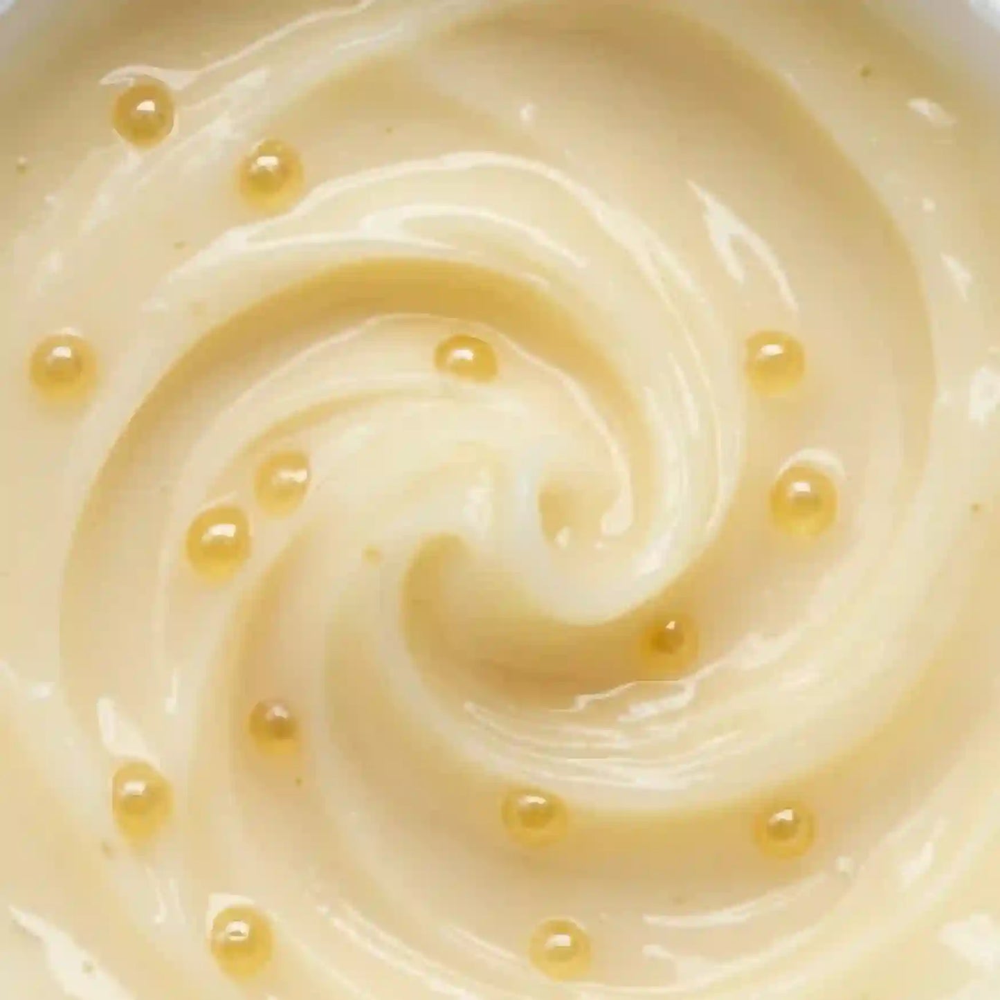 Close-up of creamy beige substance with small droplets