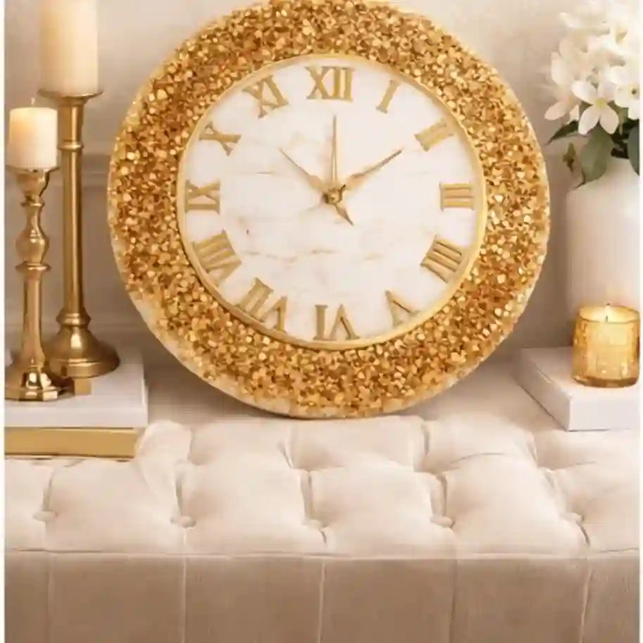 Decorative wall clock with gold embellishments on a white surface