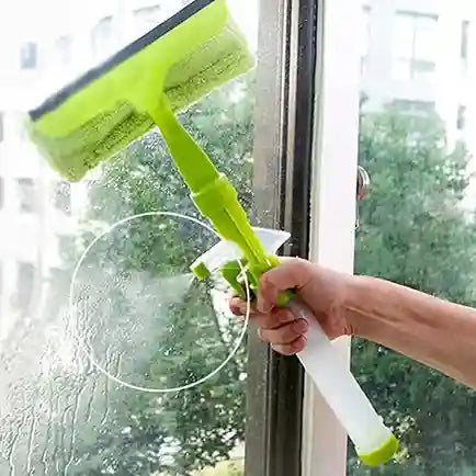 Person cleaning a window with a green squeegee and spray bottle.