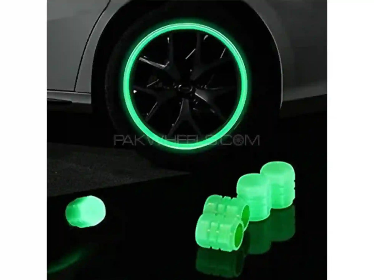 Car wheel with green rim and additional green wheel rim covers on a black surface.