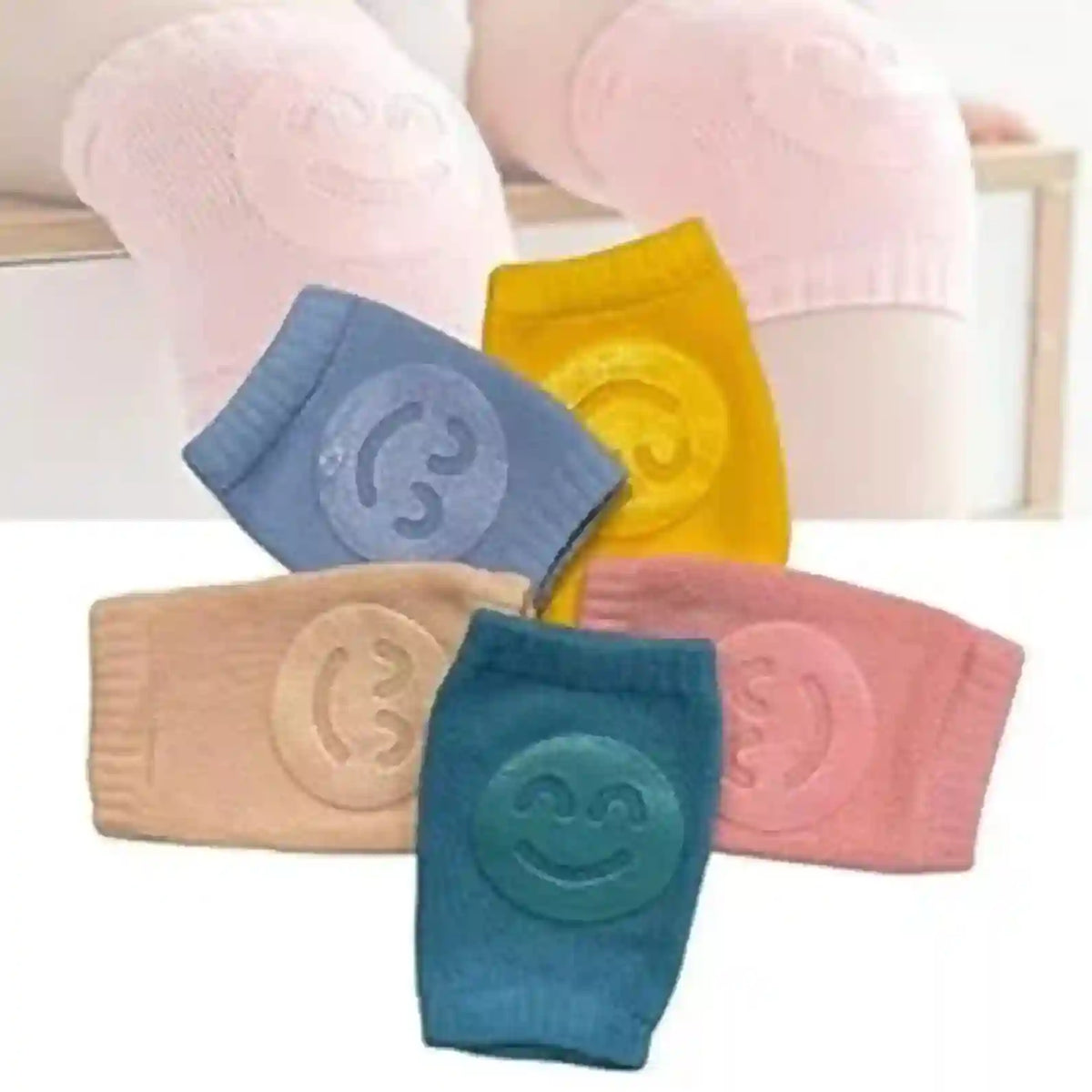 Five colorful knee pads with smiley face designs on a white background