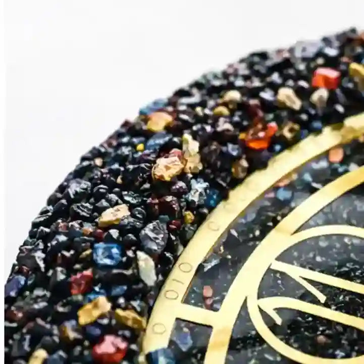 Close-up of a decorative object with embedded stones and gold accents on a white background
