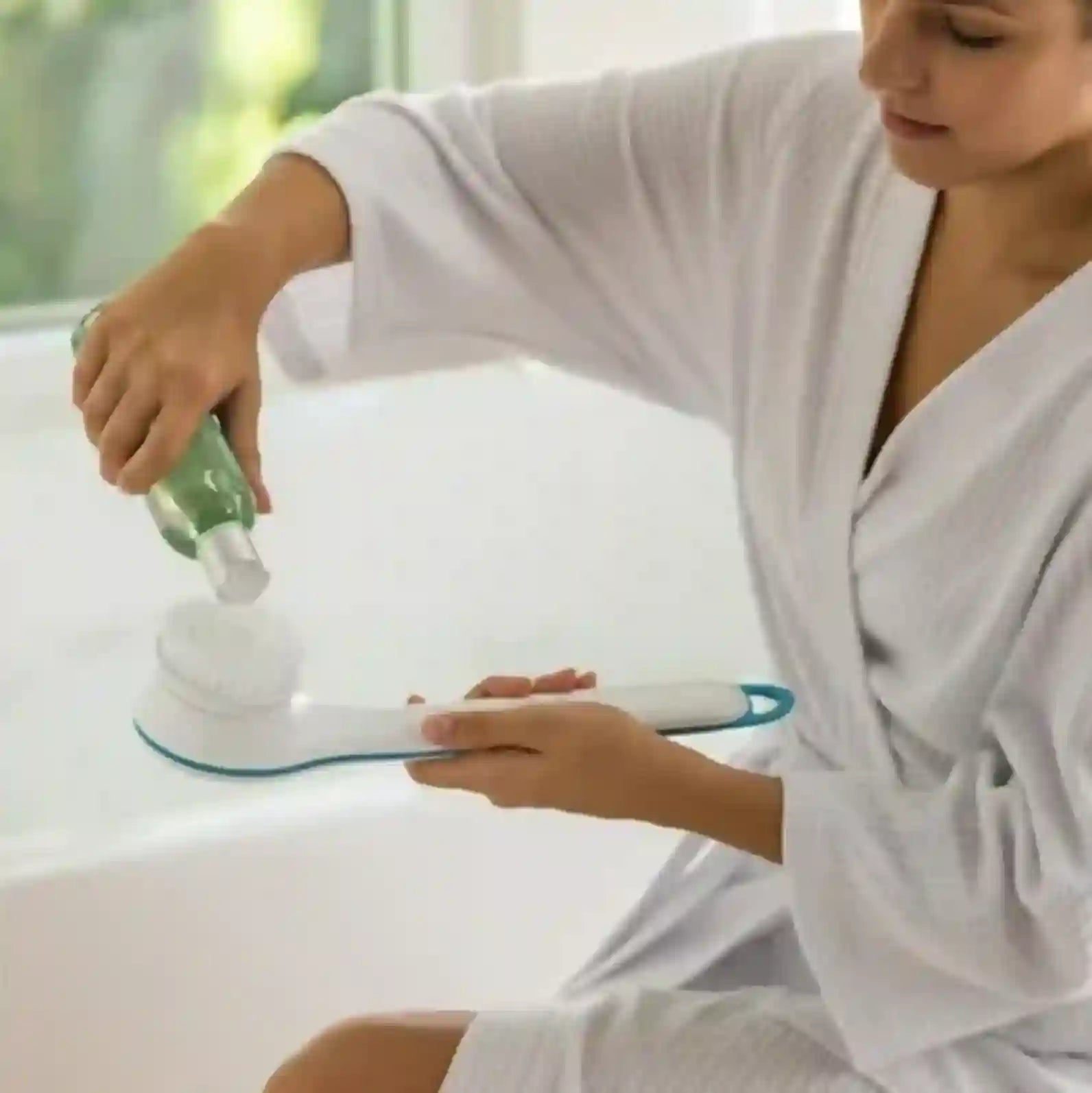 Person in a white robe using a handheld device on a white surface