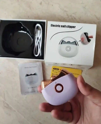 Electric nail clipper with packaging and accessories on a wooden surface