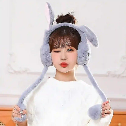 Person wearing a gray bunny ear hat against a white background