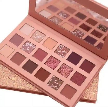 Makeup palette with various shades of eyeshadows on a white background