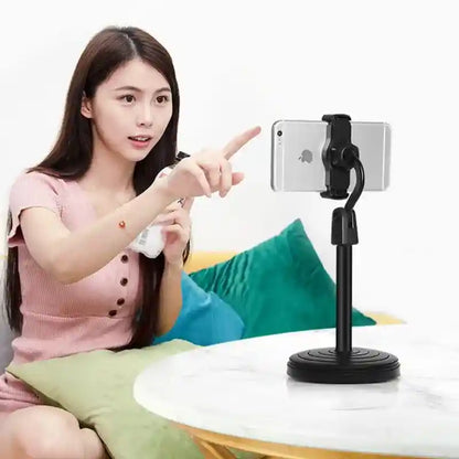 Woman pointing at a smartphone holder on a table