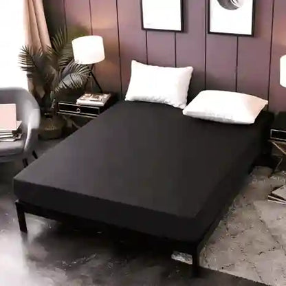 Black bed cover on a bed in a bedroom setting with decor elements.