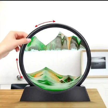 Circular object with mountain and cloud design, held by a hand on a wooden surface.