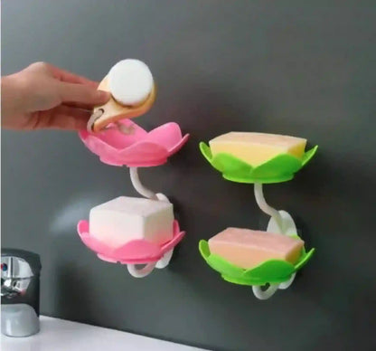 Three colorful soap holders on a wall with a hand holding a soap dish.