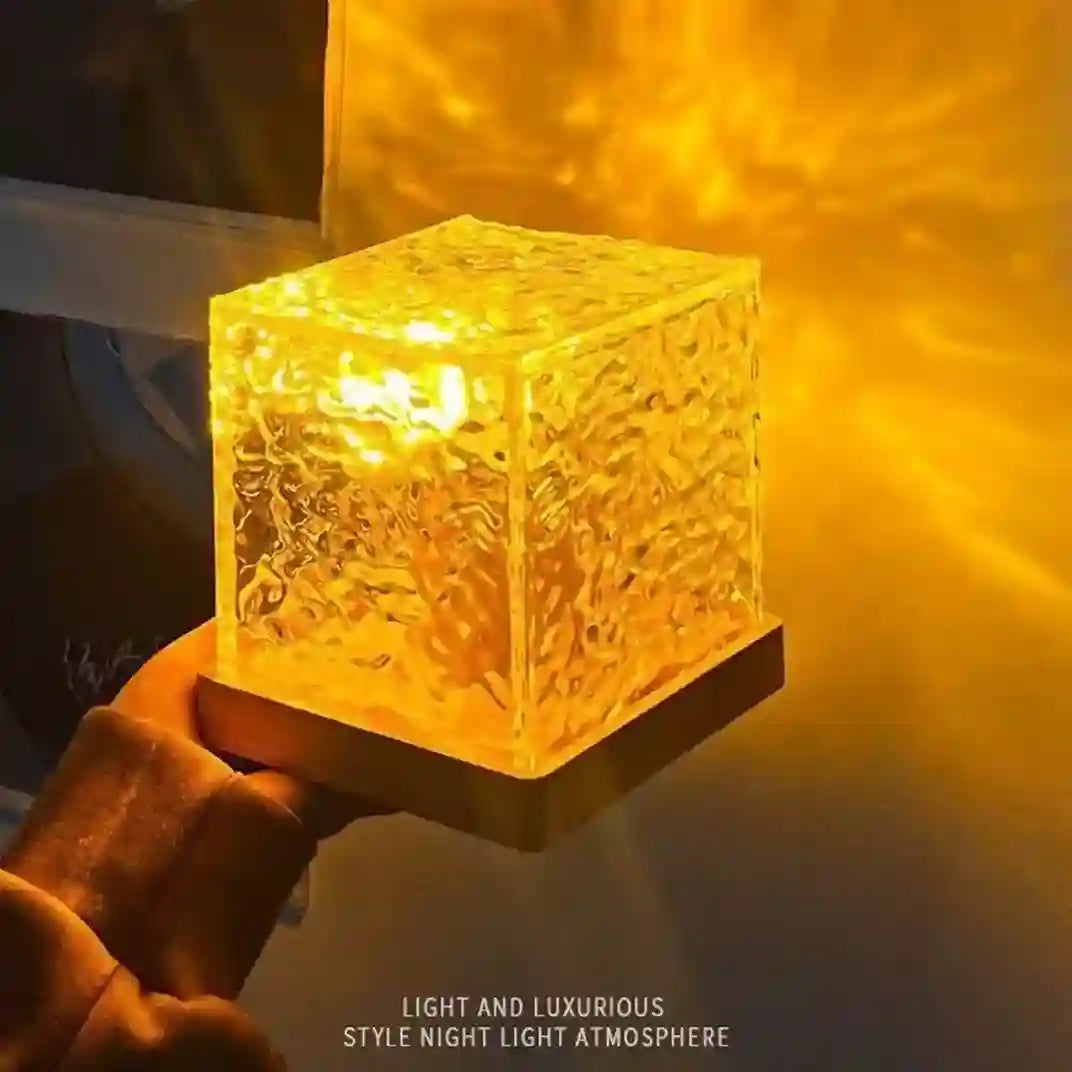 Glass cube night light emitting a warm glow on a dark background