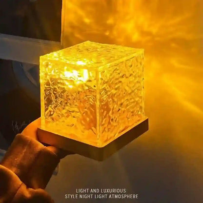 Glass cube night light emitting a warm glow on a dark background
