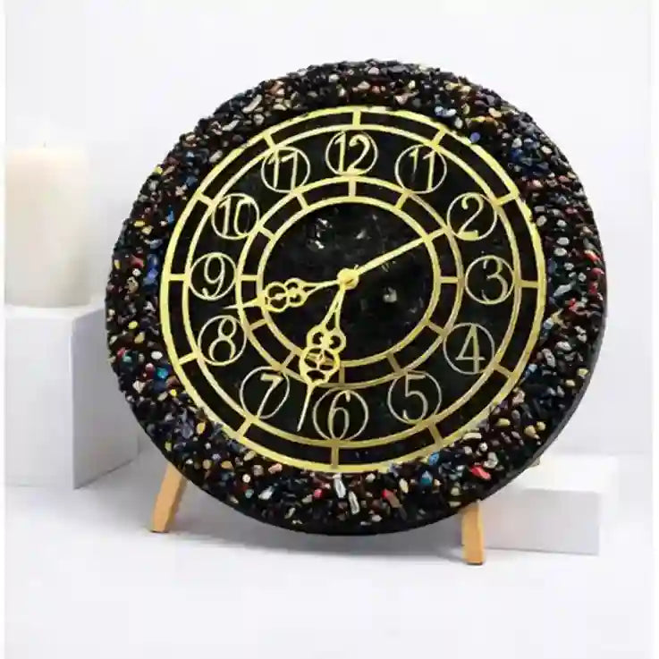 Decorative clock with black and gold design on a white background
