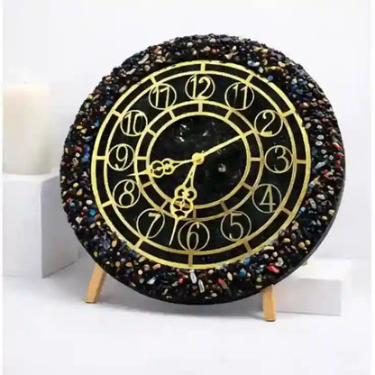Decorative clock with black and gold design on a white background