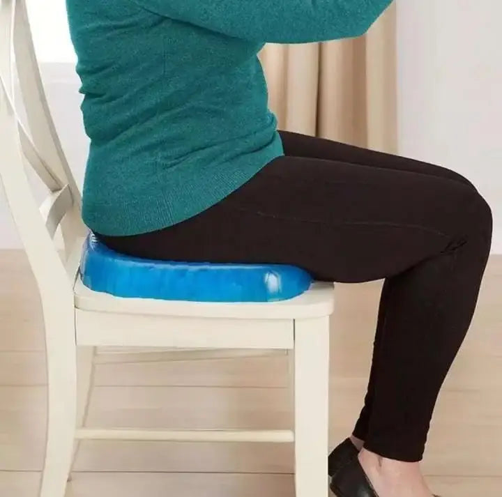 Person sitting on a blue cushioned stool on a chair indoors.