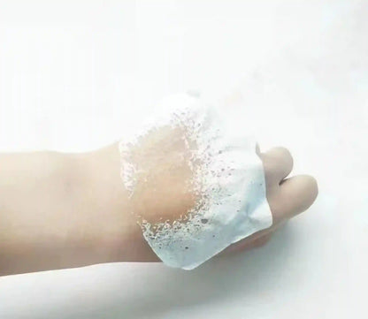 Hand holding a soapy lather against a white background