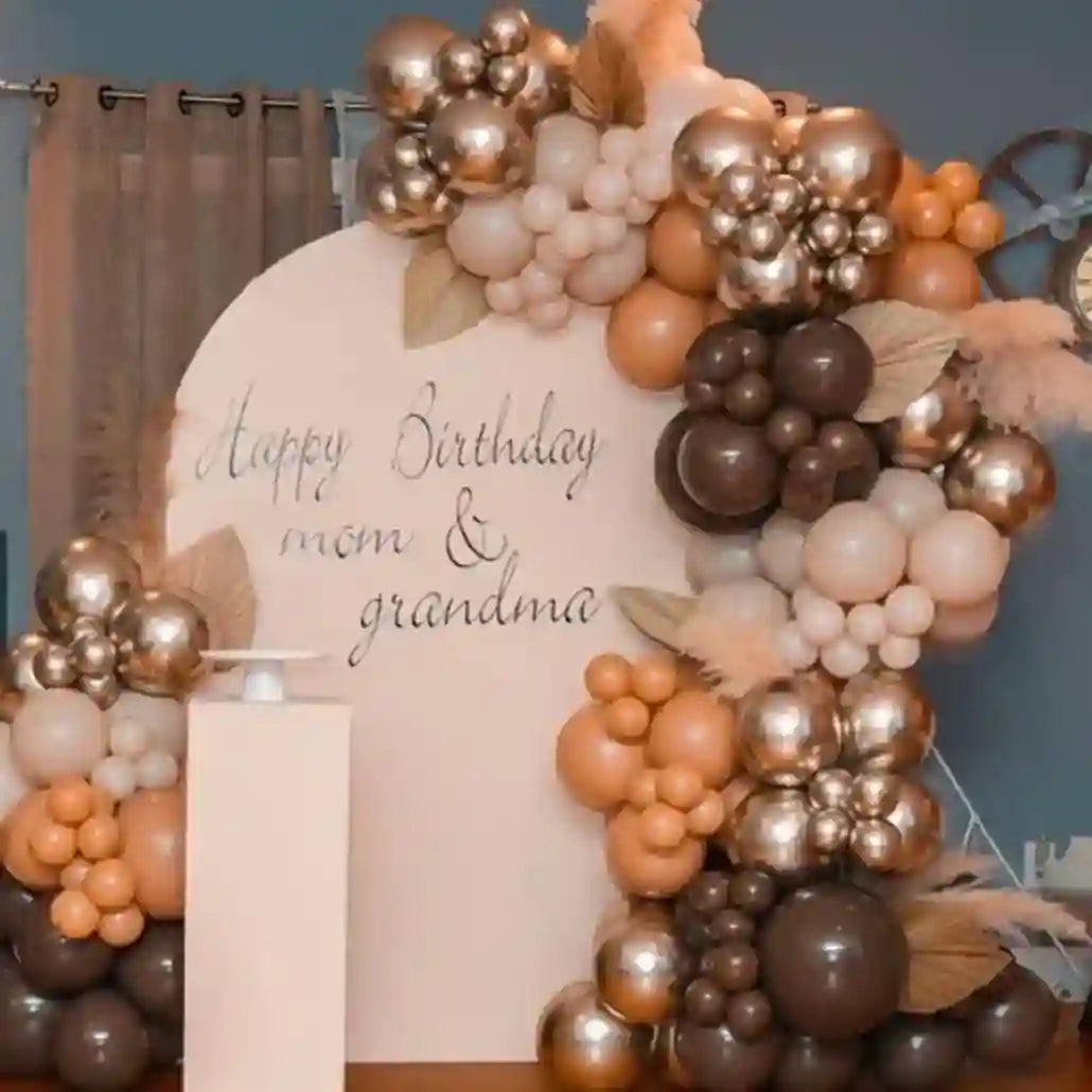 Balloon arch with 'Happy Birthday mom & grandma' text in a room setting.