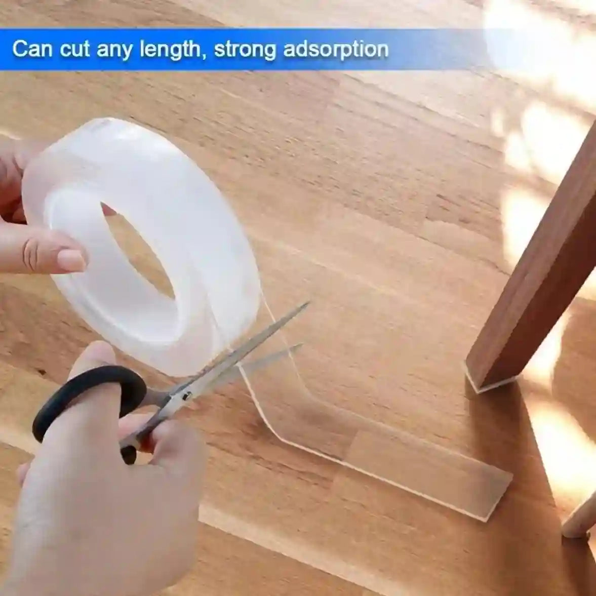 Person cutting clear tape with scissors on a wooden surface