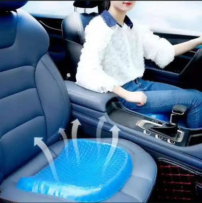 Person sitting in a car with a blue gel seat cushion on the driver's seat.