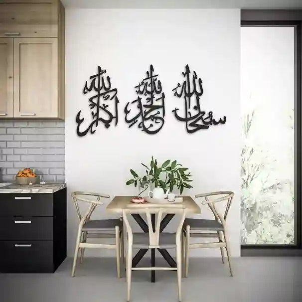 Dining area with a table and chairs, featuring Arabic calligraphy on the wall.