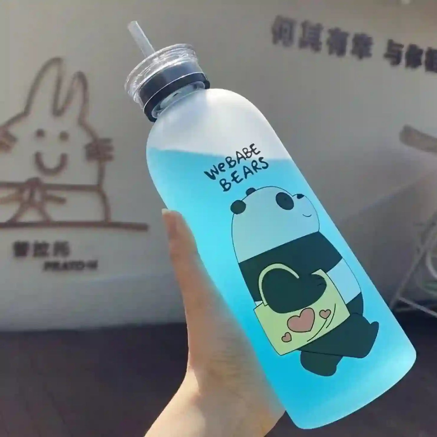 Clear water bottle with panda design and 'We Babe Bears' text, held by a hand.
