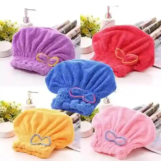 Set of colorful towel hats with decorative bows on a bathroom counter.