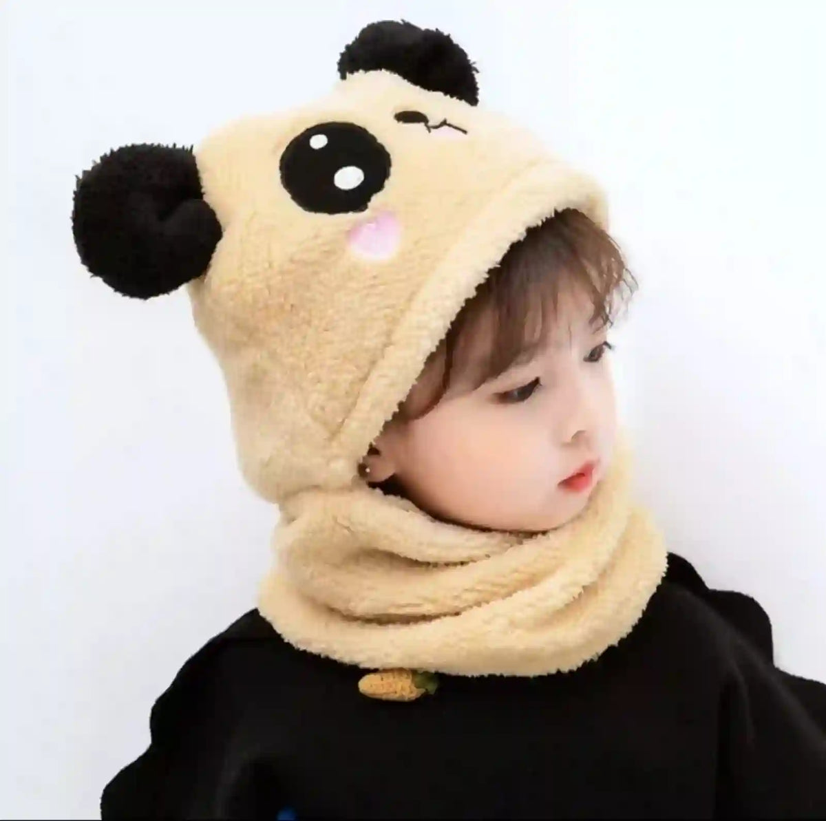Child wearing a beige hood with panda ears on a white background