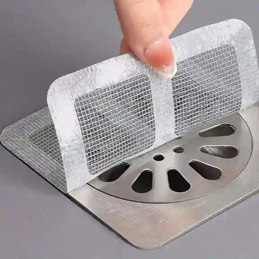 Plumbing drain cover with mesh filter being held over a drain.