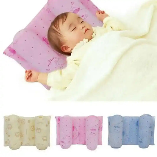 Baby sleeping on a pink pillow with three additional pillows displayed below.