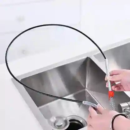 Person using a flexible cleaning tool to clean a kitchen sink.