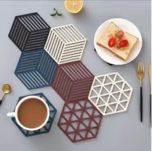 Hexagonal coasters with geometric patterns on a table with a cup of coffee and a plate of food.