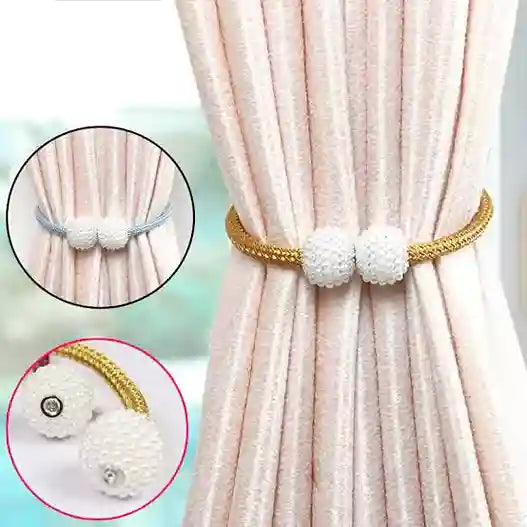 Curtain tieback with decorative pom-poms on a light pink curtain.