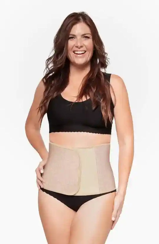 Woman wearing a beige waist trainer with a plain background