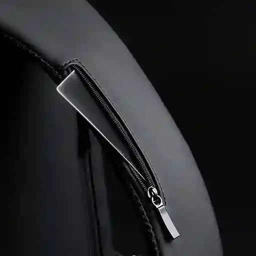 Close-up of a black leather bag with a silver zipper on a dark background