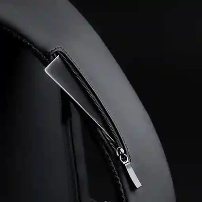 Close-up of a black leather bag with a silver zipper on a dark background
