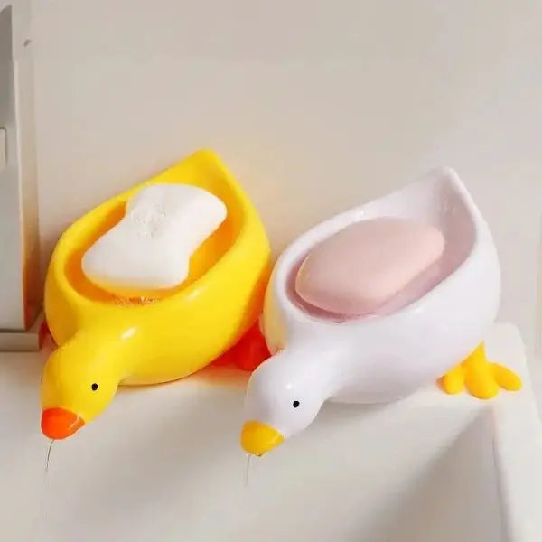 Two duck-shaped soap holders on a white background