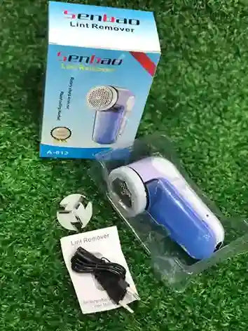 Blue and white lint remover with packaging on a grass-like background
