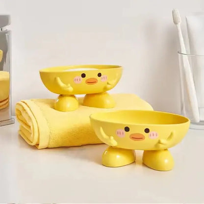 Two yellow ceramic bowls with duck face designs on a white surface.