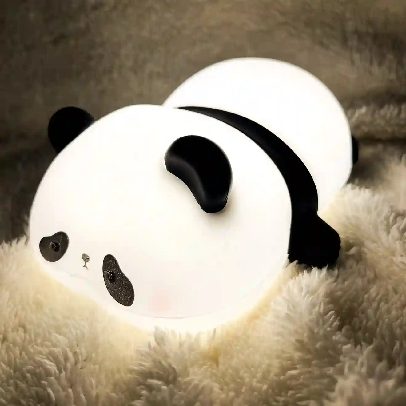 Panda-shaped night light on a soft surface