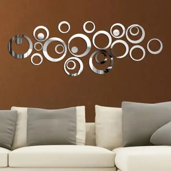 Decorative wall art with circular mirrors on a brown wall above a sofa.
