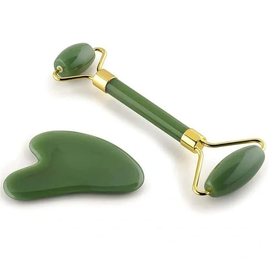 Green jade roller and gua sha tool on a white background
