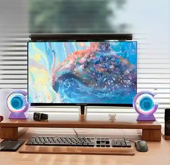 Computer setup with a monitor, keyboard, and speakers on a desk.