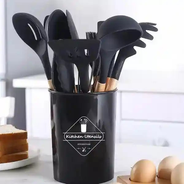Black kitchen utensil holder with various utensils on a white surface.