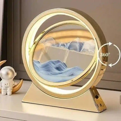 A gold-framed rotating tabletop mirror with a 360-degree swing, featuring a blue and white marbled landscape design in the center. The mirror is shown on a light-colored surface next to a small astronaut figurine, with a graphic overlay indicating the 360-degree rotation.